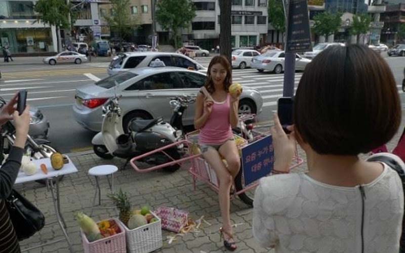 韓國街頭身穿熱褲秀長腿辣妹，擺地攤賣水果，一顆蘋果竟要價1300台幣？！就近一看才發現．．